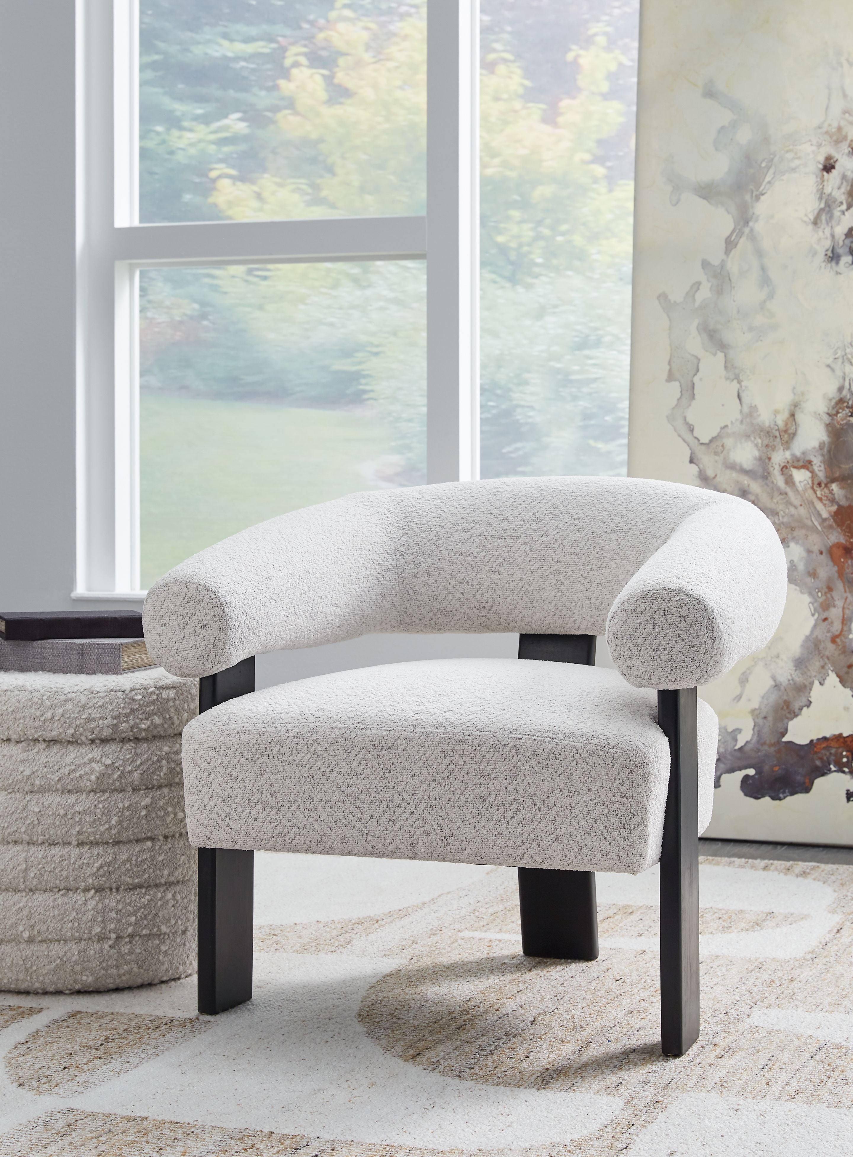Light gray upholstered accent chair with rounded arms and dark legs