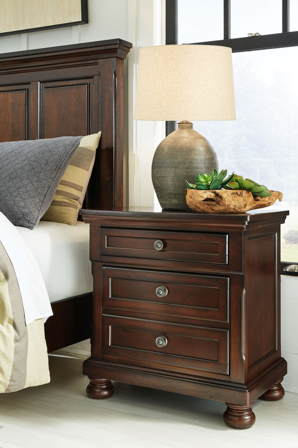 Dark brown night stand with drawer fronts and round metal pulls