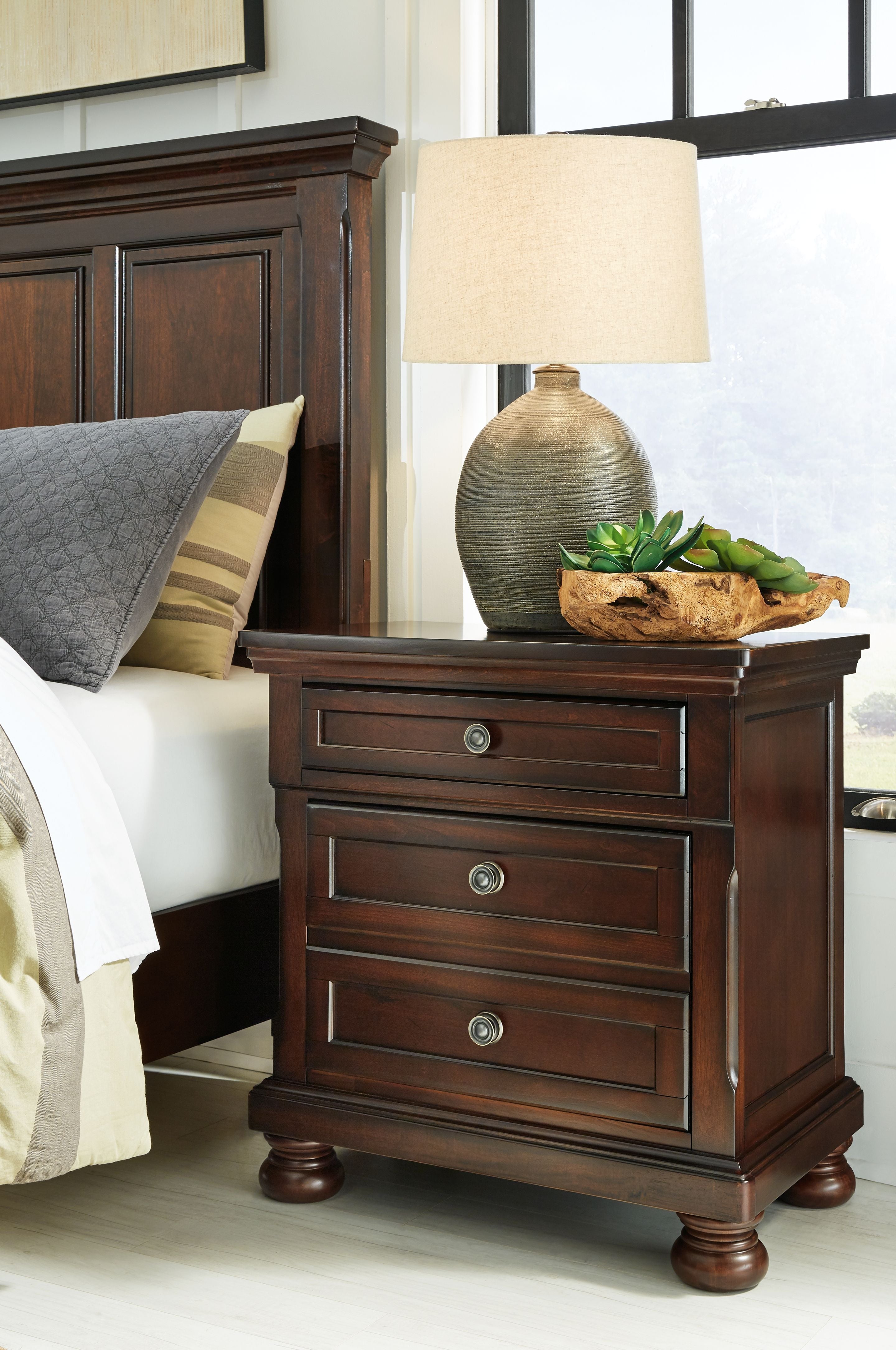 Dark brown night stand with drawer fronts and round metal pulls