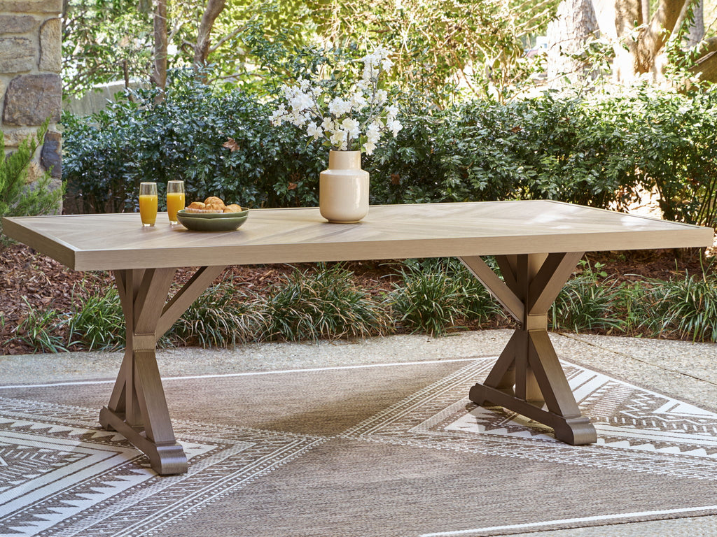 Rectangular dining table with slatted beige top and pedestal X legs.