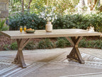 Rectangular dining table with slatted beige top and pedestal X legs.
