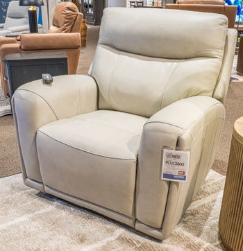 Light beige padded recliner chair with wide arms and smooth upholstered seat