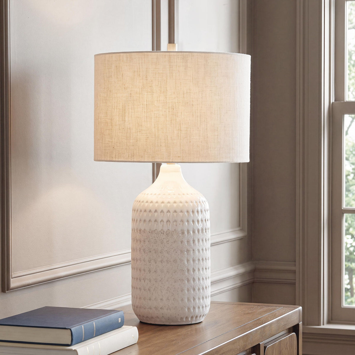 Ceramic table lamp with beige linen drum shade and textured white vase base