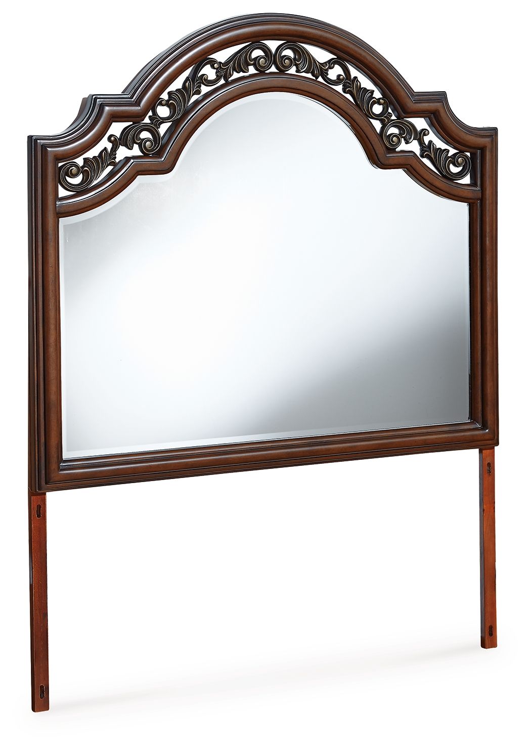 Brown arched bedroom mirror with ornate carved frame trim