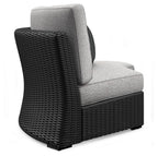Black woven armchair with light gray seat cushion and tall curved backrest