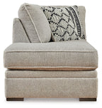 Gray corner chaise with patterned lumbar pillow and textured side cushion