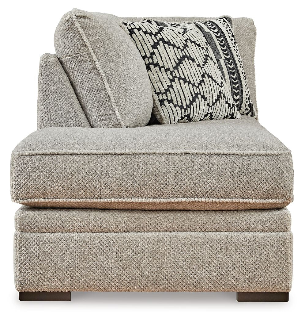 Gray corner chaise with patterned lumbar pillow and textured side cushion