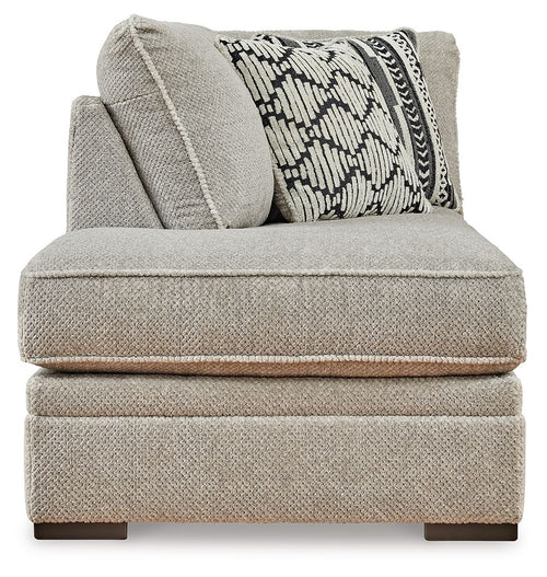 Gray corner chaise with patterned lumbar pillow and textured side cushion