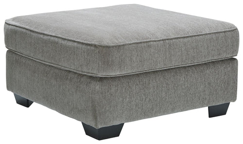 Light gray upholstered accent ottoman with padded top and short dark square legs