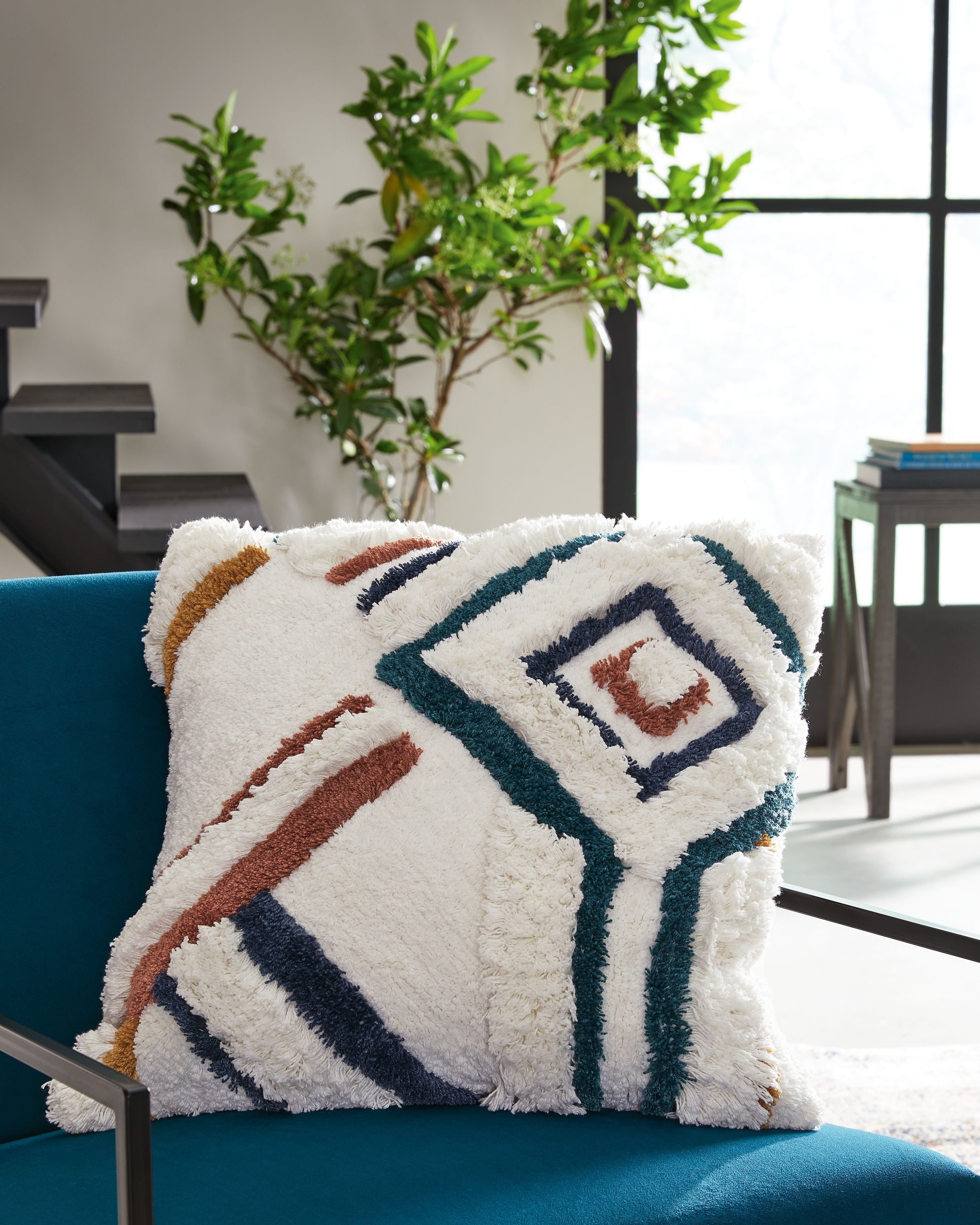 Evermore pillow with fuzzy white front and layered diamond embroidery in dark blue and rust