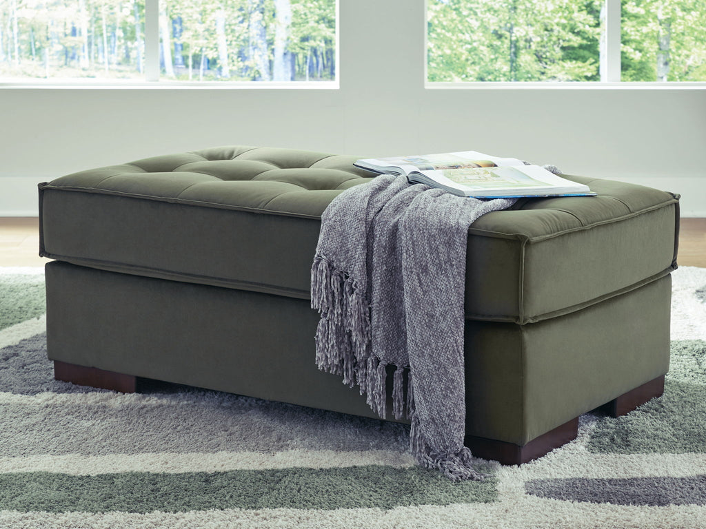 Olive upholstered accent ottoman with tufted top and draped throw blanket