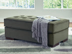 Olive upholstered accent ottoman with tufted top and draped throw blanket