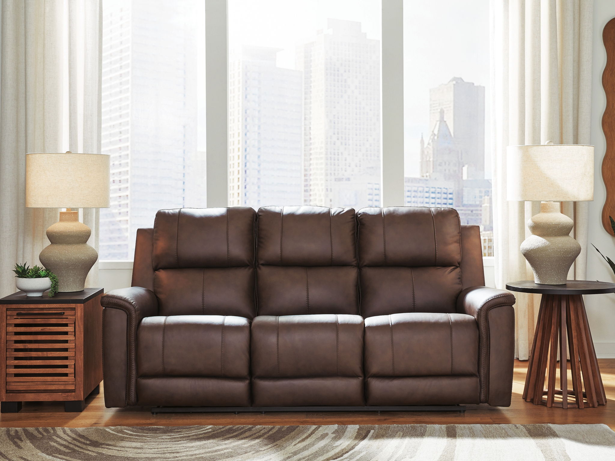 Dark brown power reclining sofa with three padded headrests and quilted seat cushions