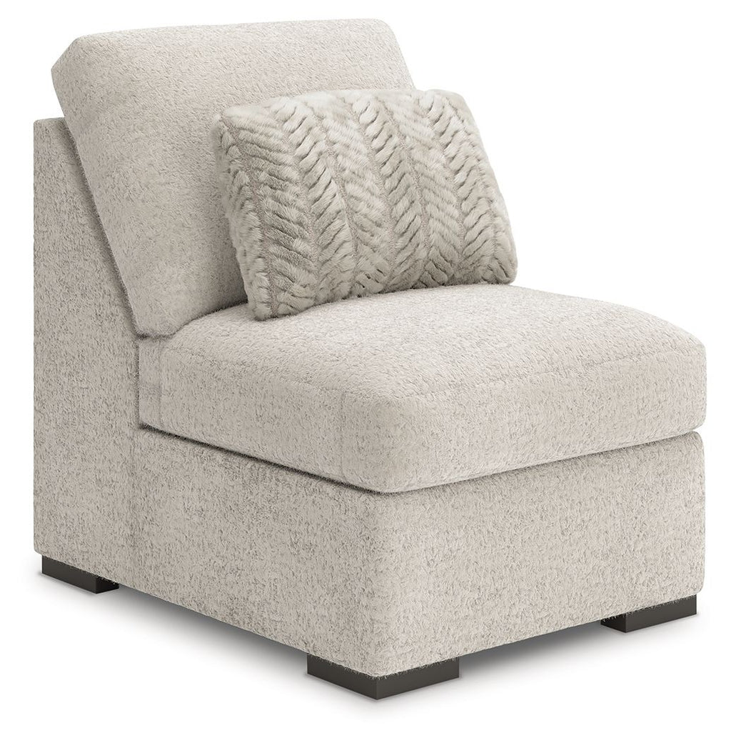 Light gray armless chair with textured upholstery, patterned back pillow, and dark legs