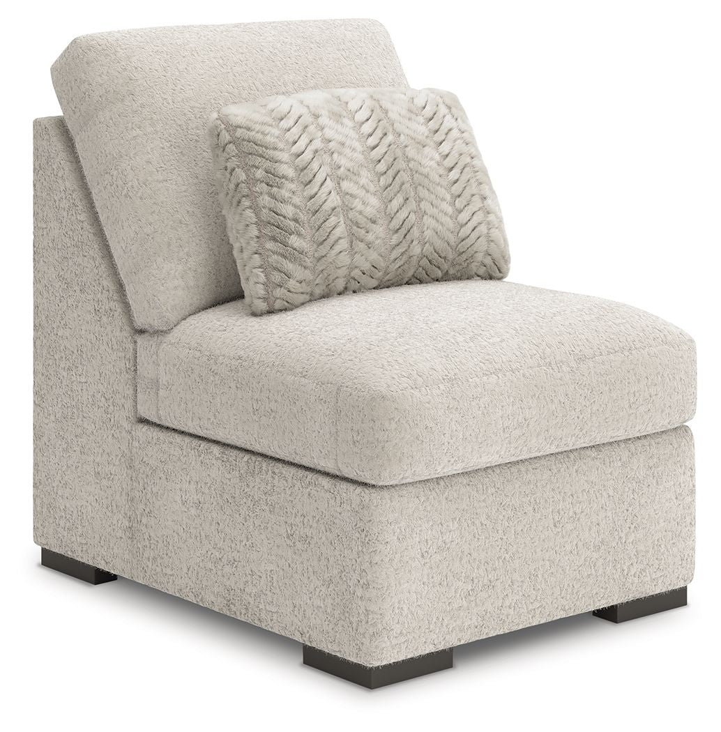 Light gray armless chair with textured upholstery, patterned back pillow, and dark legs