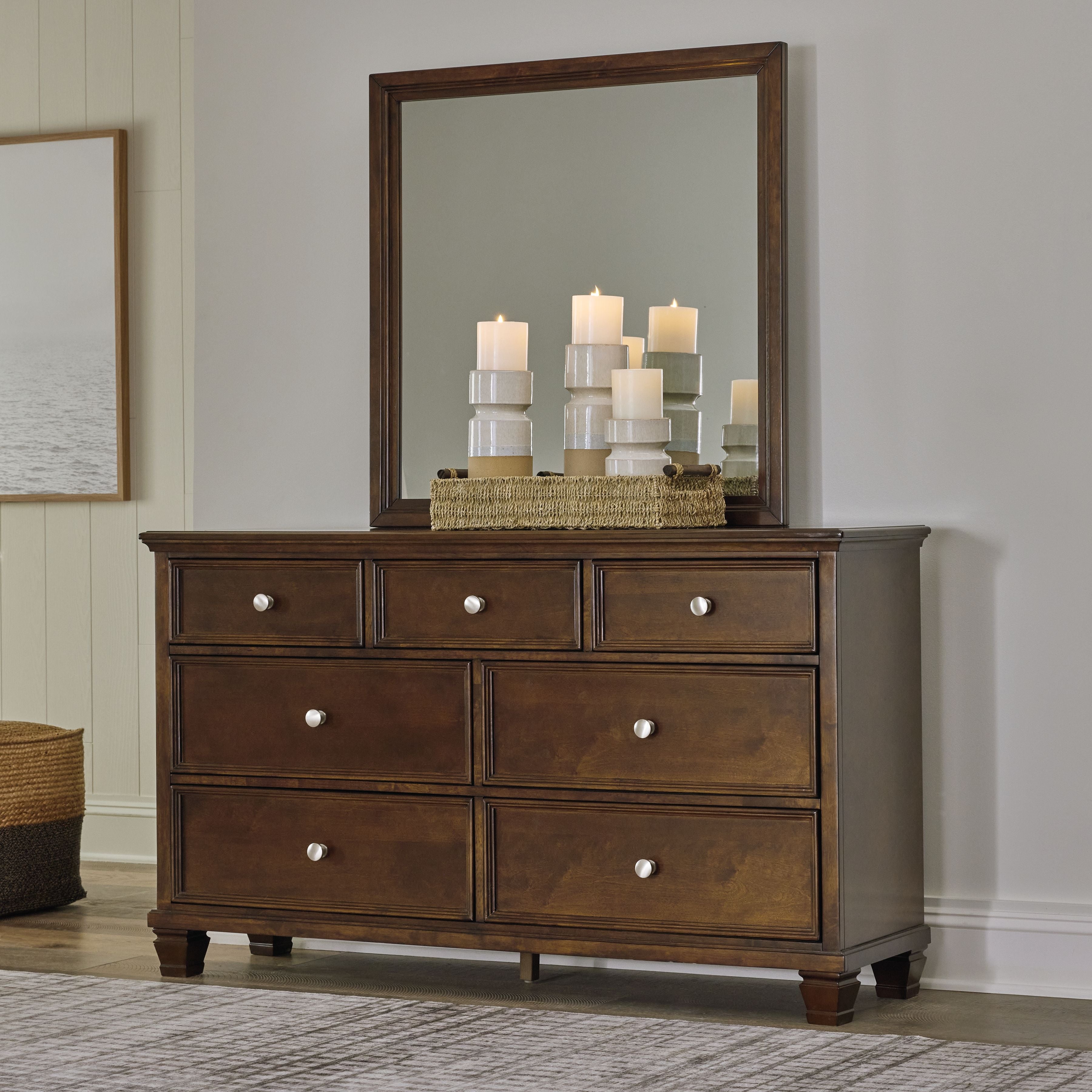 Brown dresser with framed mirror and drawer fronts, round metal knobs.