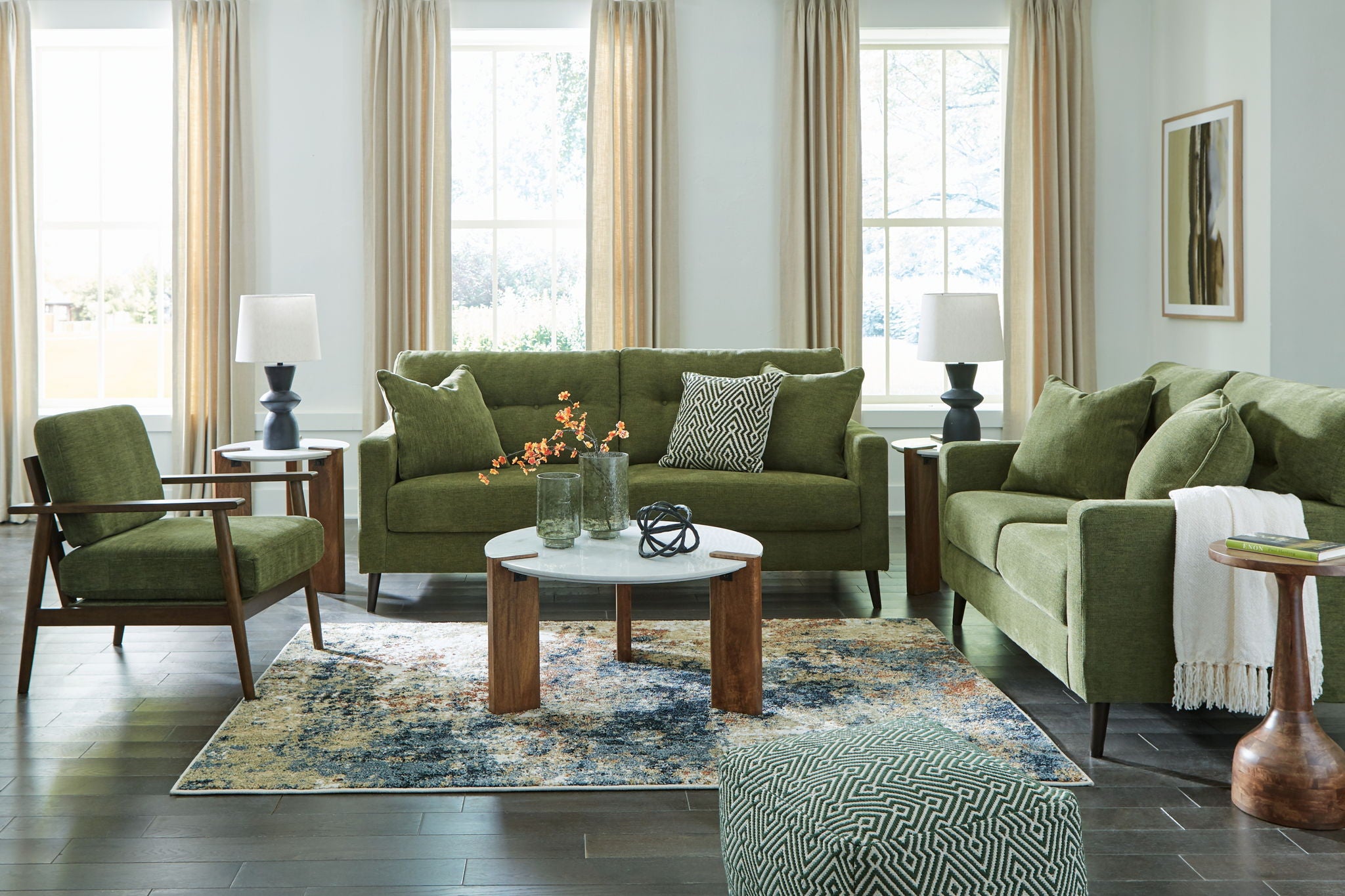 Green living room sofa and two armchairs with patterned throw pillows