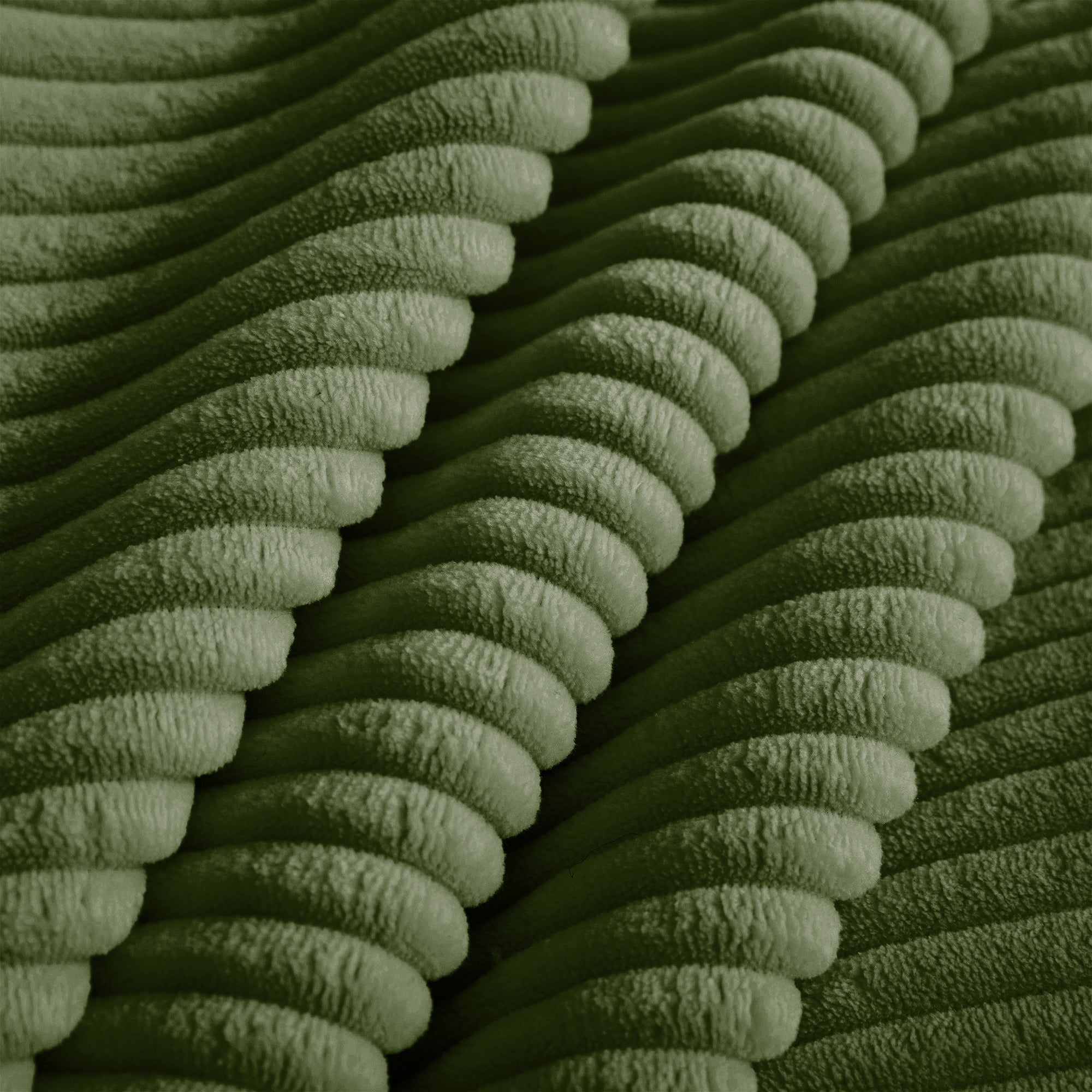Green corduroy fabric close-up with ribbed texture
