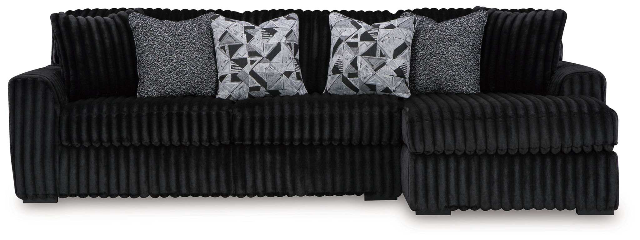 Black corded sectional sofa with gray accent pillows and geometric patterned cushions