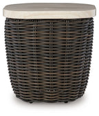 Dark brown wicker side table with round beige tabletop and raised edge