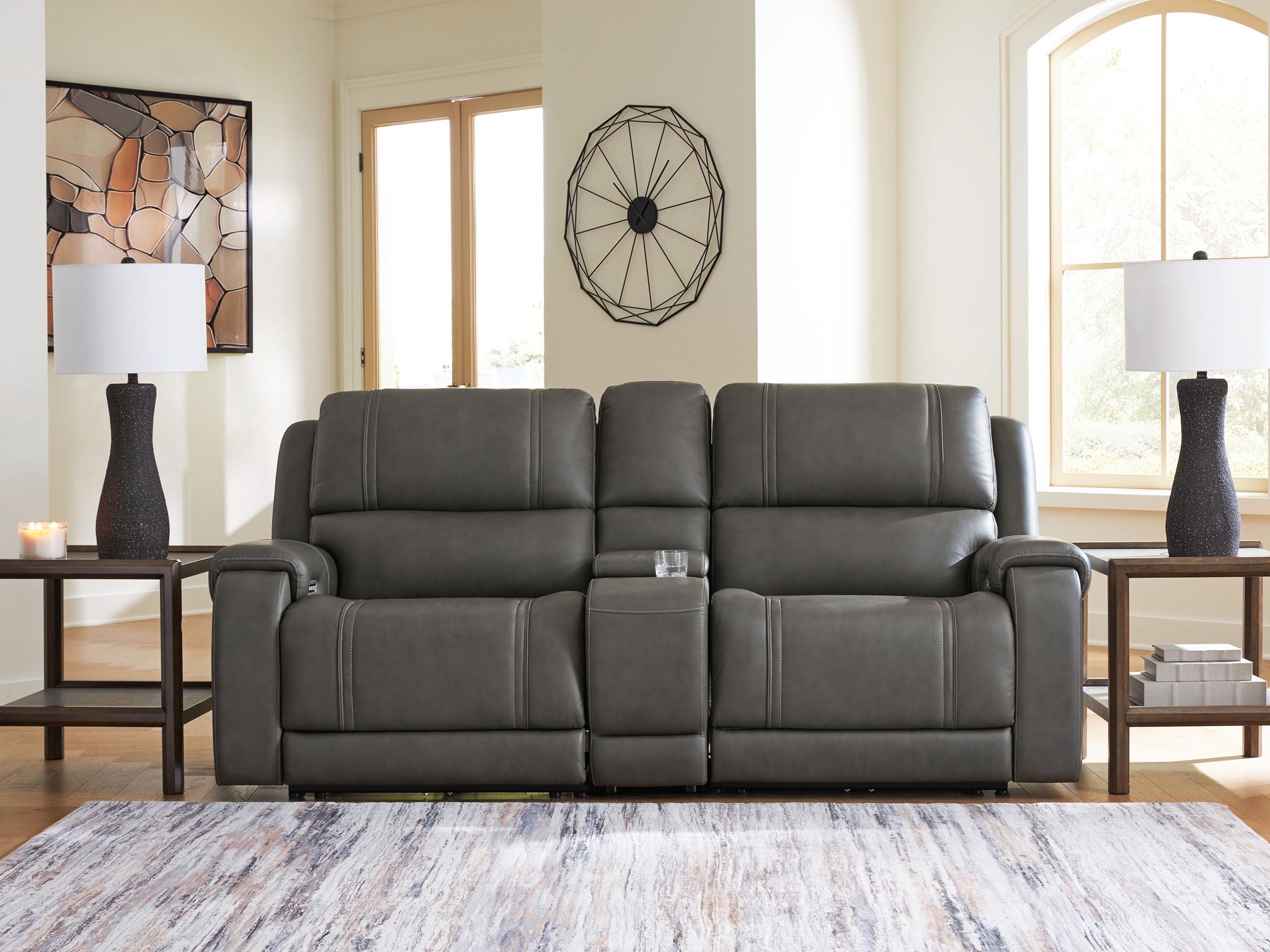 Dark gray reclining sectional with padded arms, segmented back cushions, and recline panels