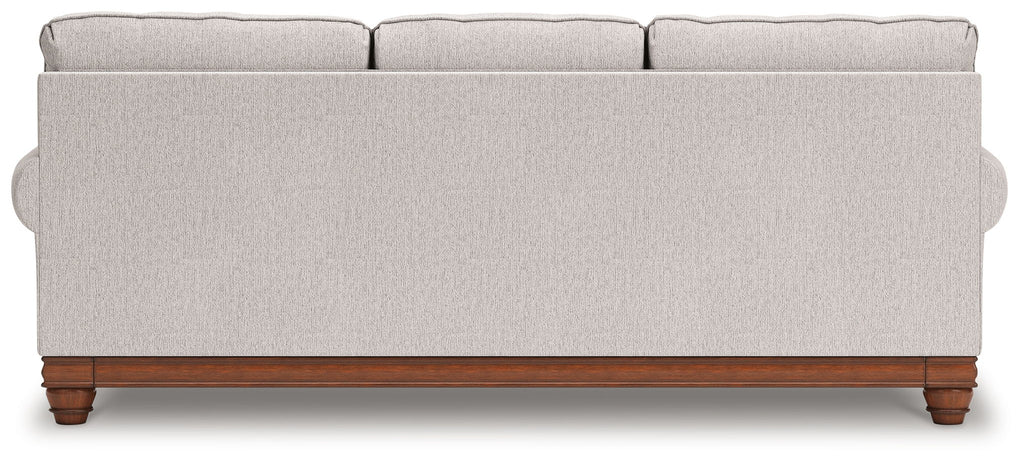 Light gray sofa back view with tufted arms and wooden legs