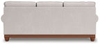 Light gray sofa back view with tufted arms and wooden legs