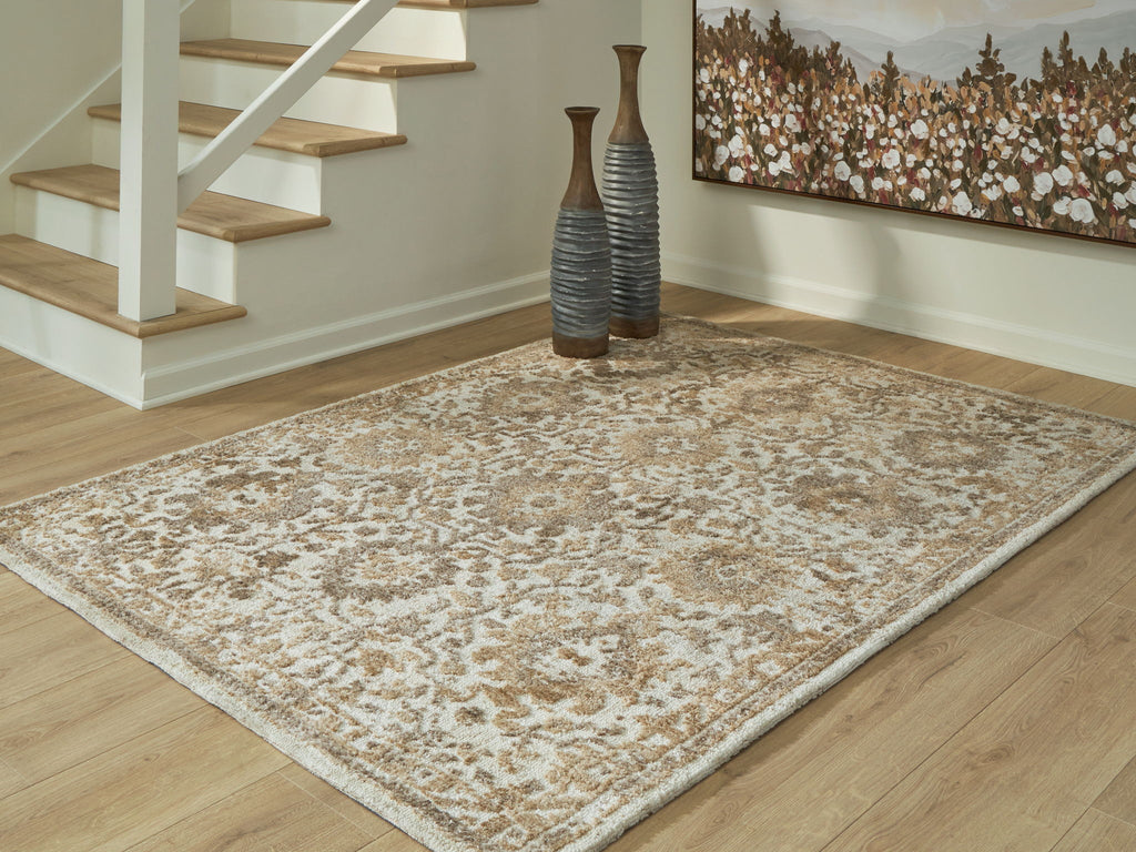 Light brown patterned area rug with distressed damask-style medallions