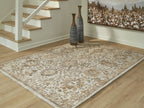 Light brown patterned area rug with distressed damask-style medallions