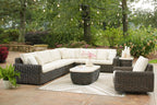 Outdoor seating set with dark brown wicker sectional, round table, and glider chair