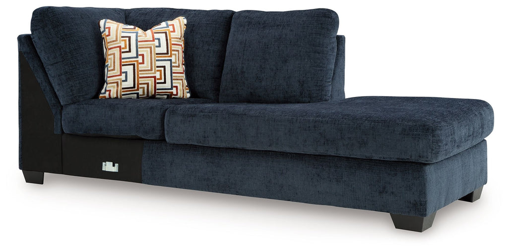 Ink blue corner chaise sofa with patterned throw pillow and dark legs