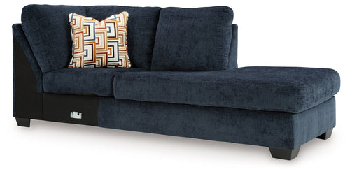 Ink blue corner chaise sofa with patterned throw pillow and dark legs