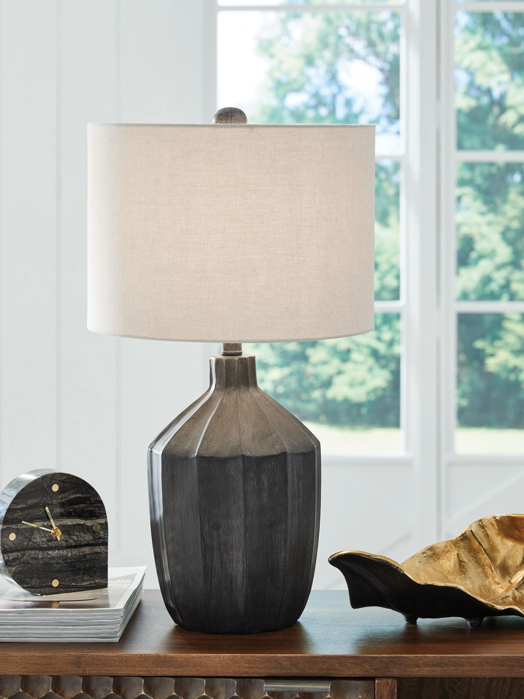 Black poly table lamp with beige drum shade on console table