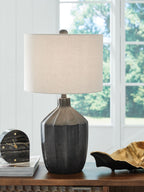Black poly table lamp with beige drum shade on console table