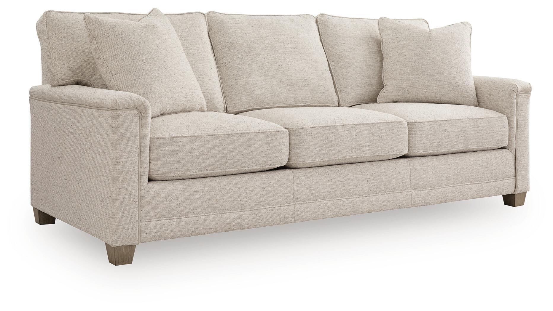 Light beige upholstered sofa with four back cushions, three seat cushions, rounded arms