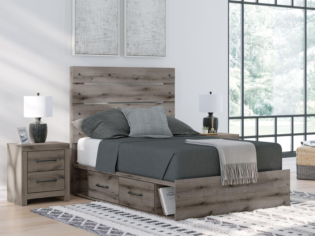 Dark gray panel bed with storage drawers, styled with gray bedding