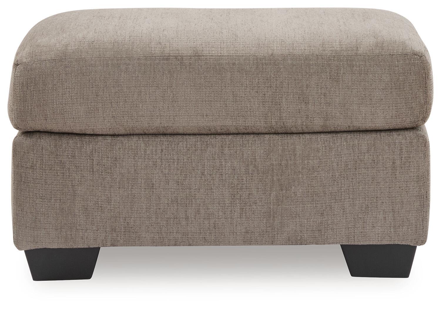 Tan fabric ottoman with thick padded top and dark block legs