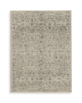 Light beige area rug with small geometric medallion pattern and distressed finish