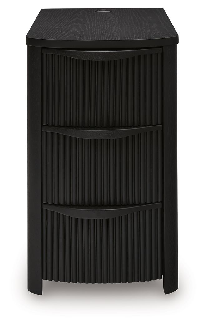 Black chair side end table with vertical slat panels and three drawer compartments