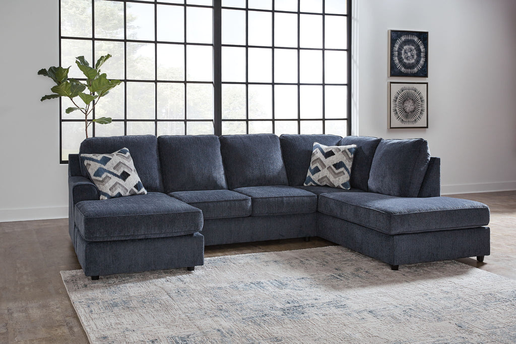 Blue sectional sofa with chaise and ottoman, three patterned square pillows