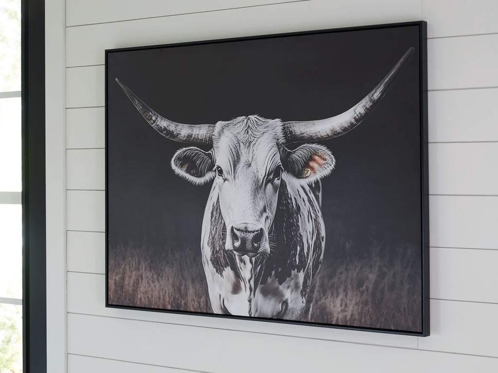 Framed wall art showing a white cow portrait with long horns on dark background