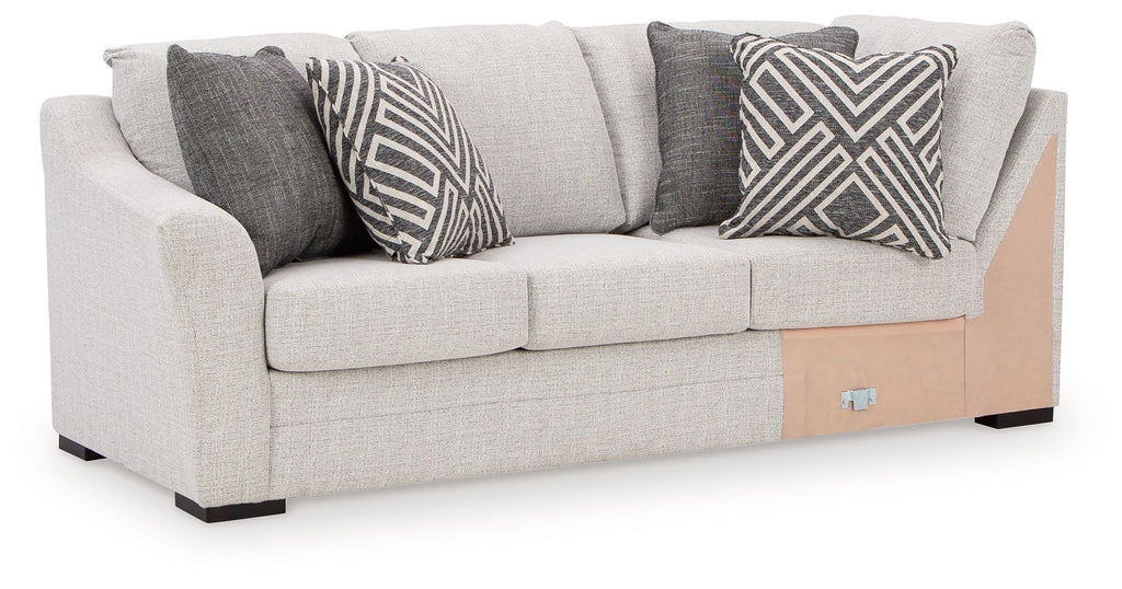 Light gray fabric sofa with corner wedge and dark chevron patterned throw pillows