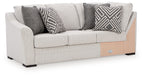 Light gray fabric sofa with corner wedge and dark chevron patterned throw pillows