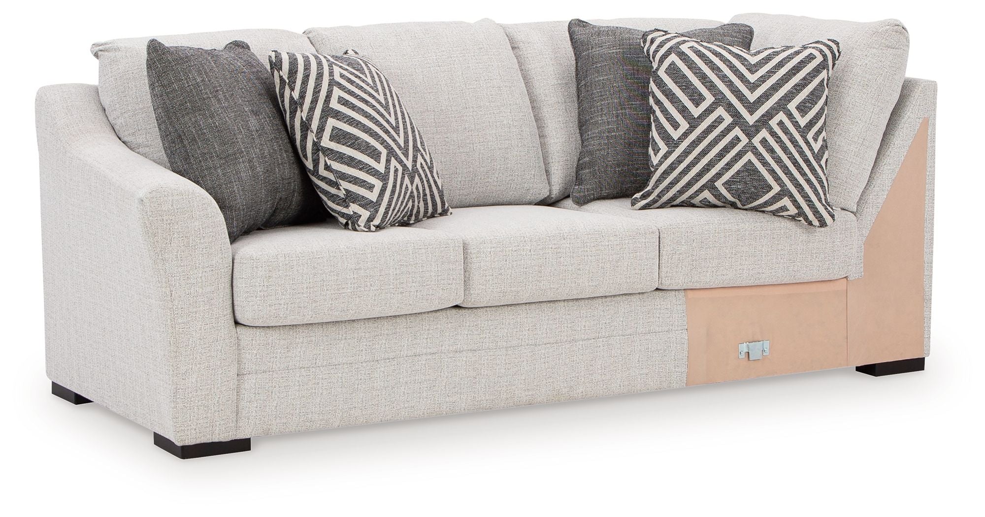 Light gray fabric sofa with corner wedge and dark chevron patterned throw pillows