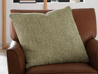 Green square throw pillow on brown leather armchair