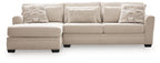 Light beige sectional sofa with chaise, clean-lined arms and two patterned accent pillows