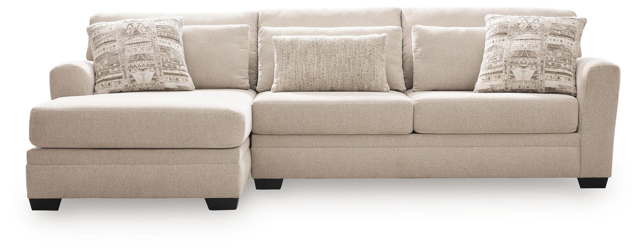 Light beige sectional sofa with chaise, clean-lined arms and two patterned accent pillows