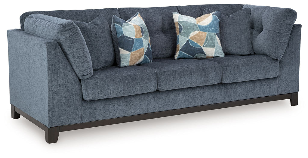 Navy fabric sofa with tufted arms and two decorative geometric throw pillows