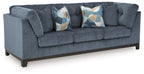 Navy fabric sofa with tufted arms and two decorative geometric throw pillows