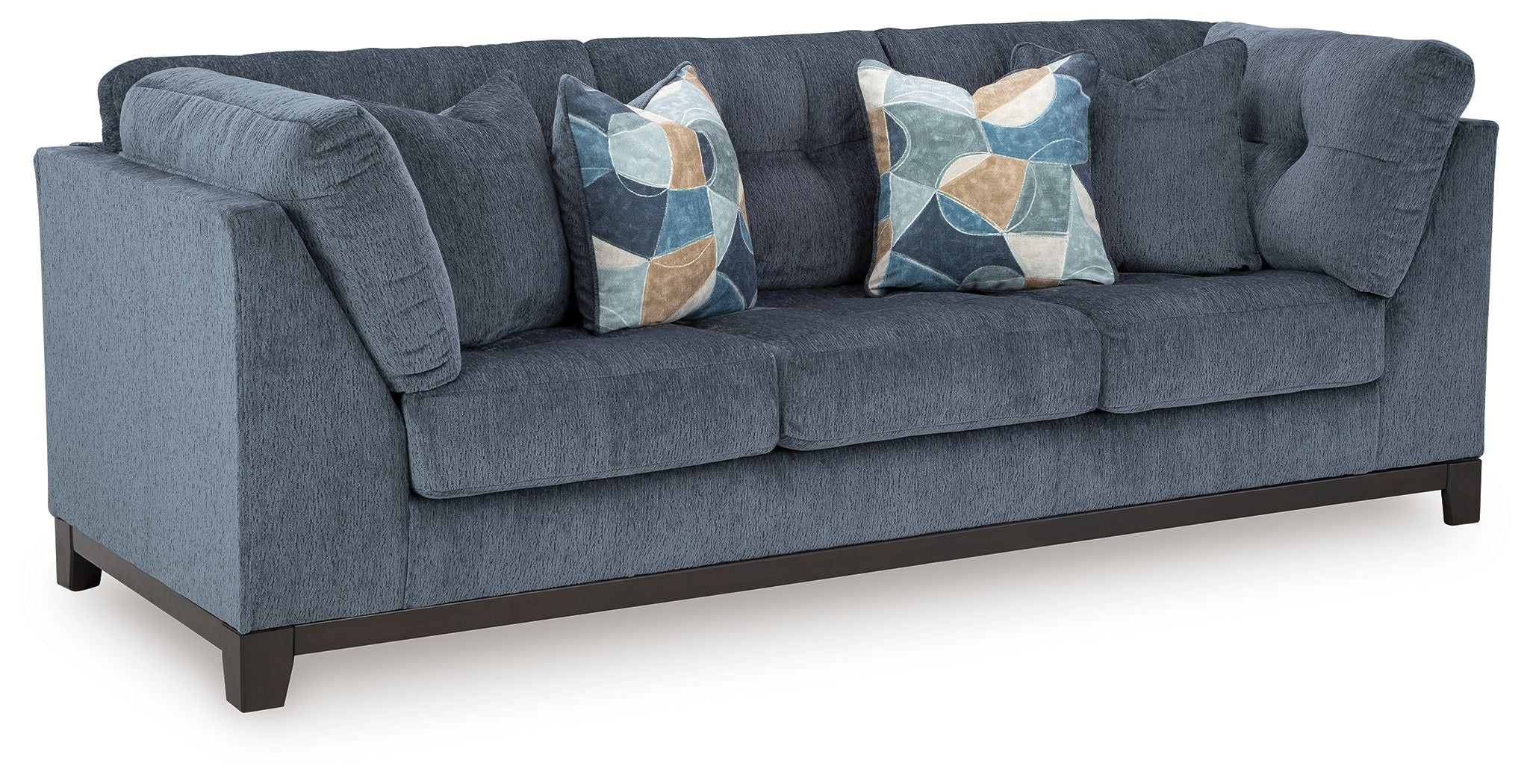 Navy fabric sofa with tufted arms and two decorative geometric throw pillows